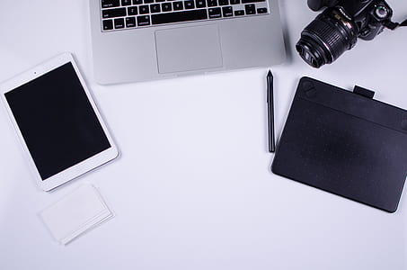 white iPad mini, MacBook Pro, and black DSLR camera