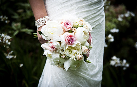 shallow focus photo of woman holding flower bouquet