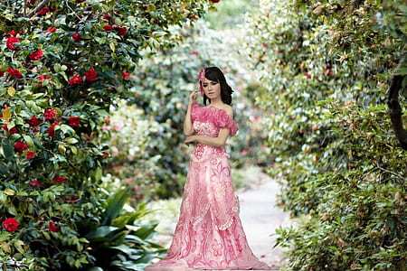 photo of woman wearing pink dress in the middle of flowers