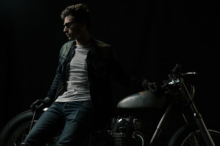 closeup photo of man leaning on standard motorcycle wearing black leather jacket