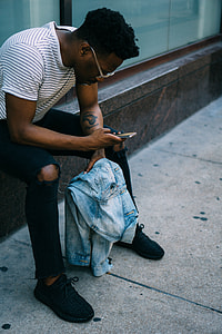man seating on side holding phone