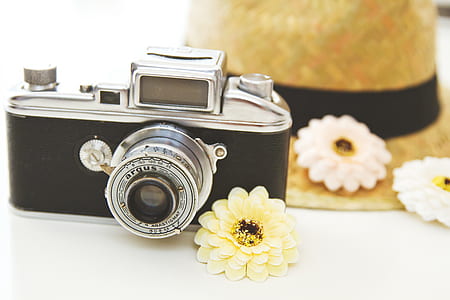 black and gray camera beside yellow petaled flower