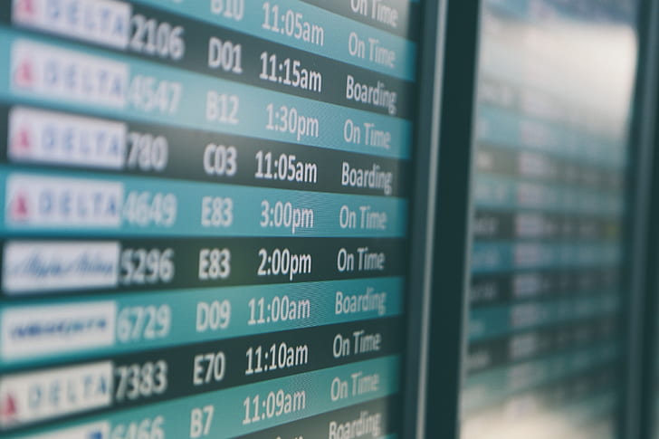 selective focus photography of plane flight schedule board
