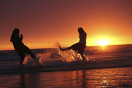 two women at shore during golden hour