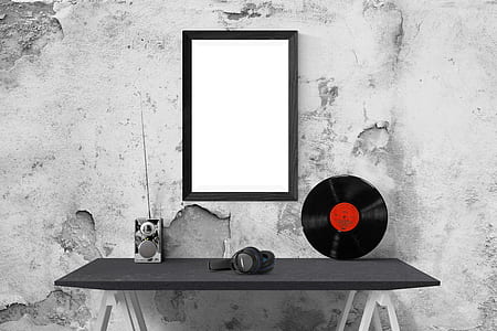 black wireless headphones on table with vinyl disc and mirror on wall