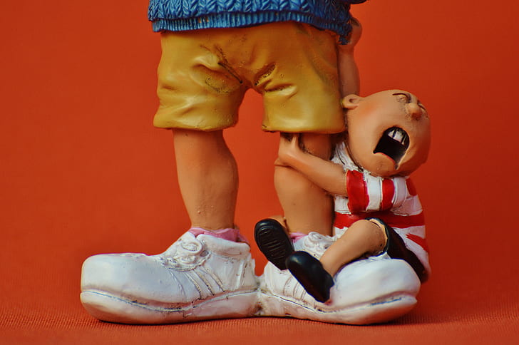 boy hugging man's foot figurine set