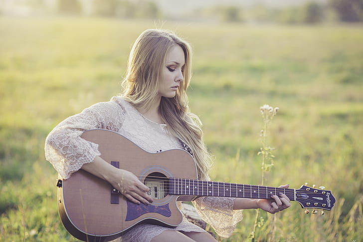 Woman Playing Brown Wooden Acoustic Guitar during Daytime
