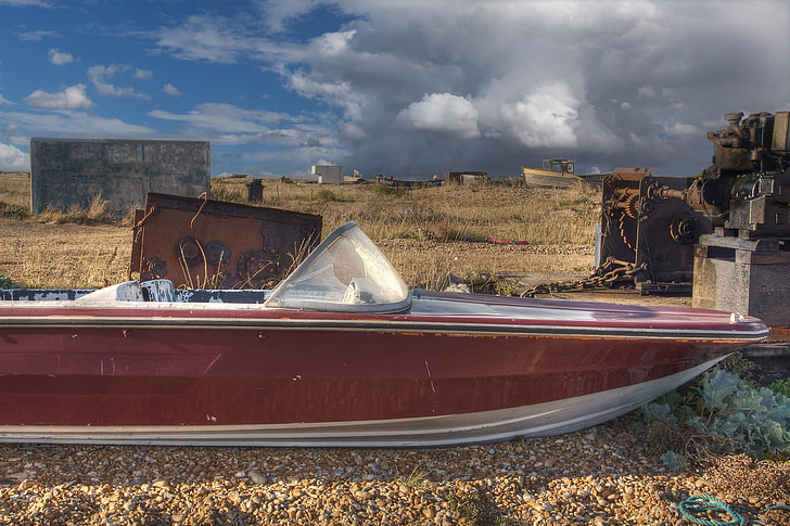 An old abandoned speed boat sits on the shingle beach at Dungeness, Kent, England