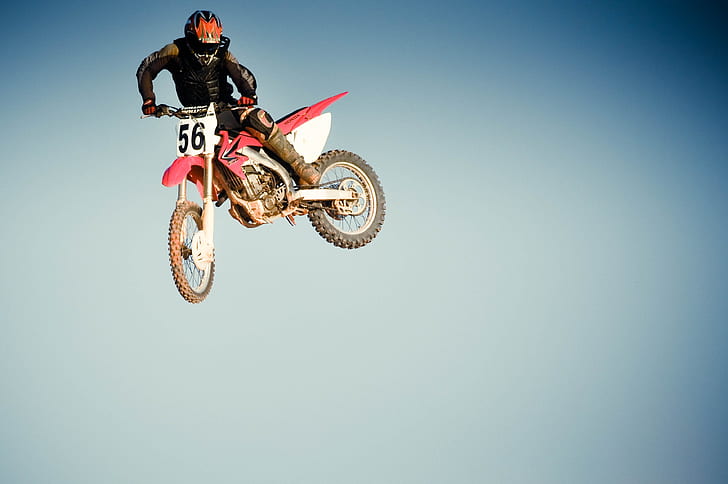 man riding in red dirt bike