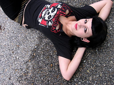 woman in black shirt lying on asphalt road