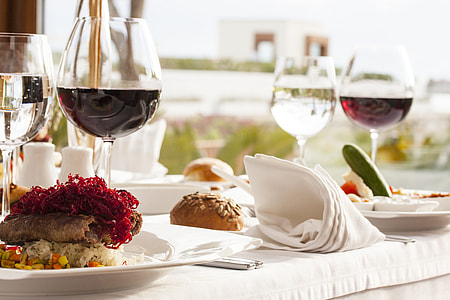 food on plate with wine glasses on table closeup photo