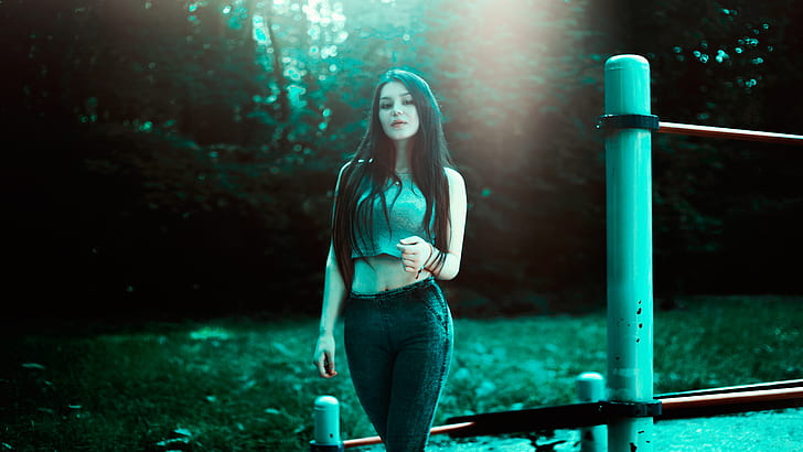 woman in gray sleeveless crop top and pants standing near post