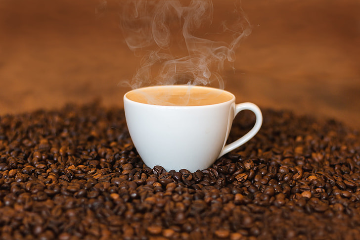 photo of hot coffee on coffee seeds
