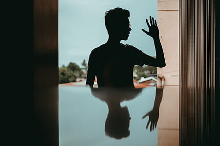 young man, reflection, silhouette, man in glass, man waving