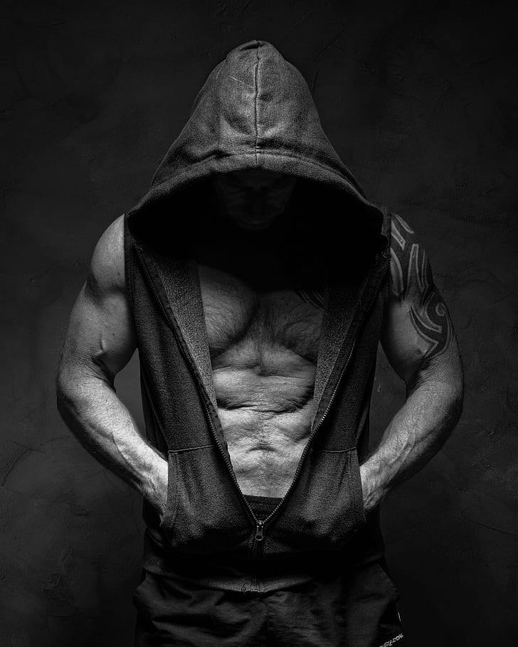 man wearing hooded vest on grayscale photo