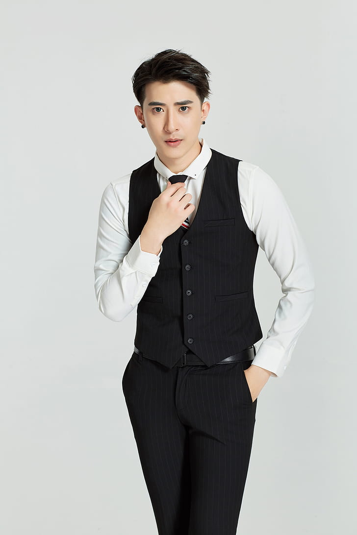 man wearing black button-up vest, white dress shirt and black dress pants outfit