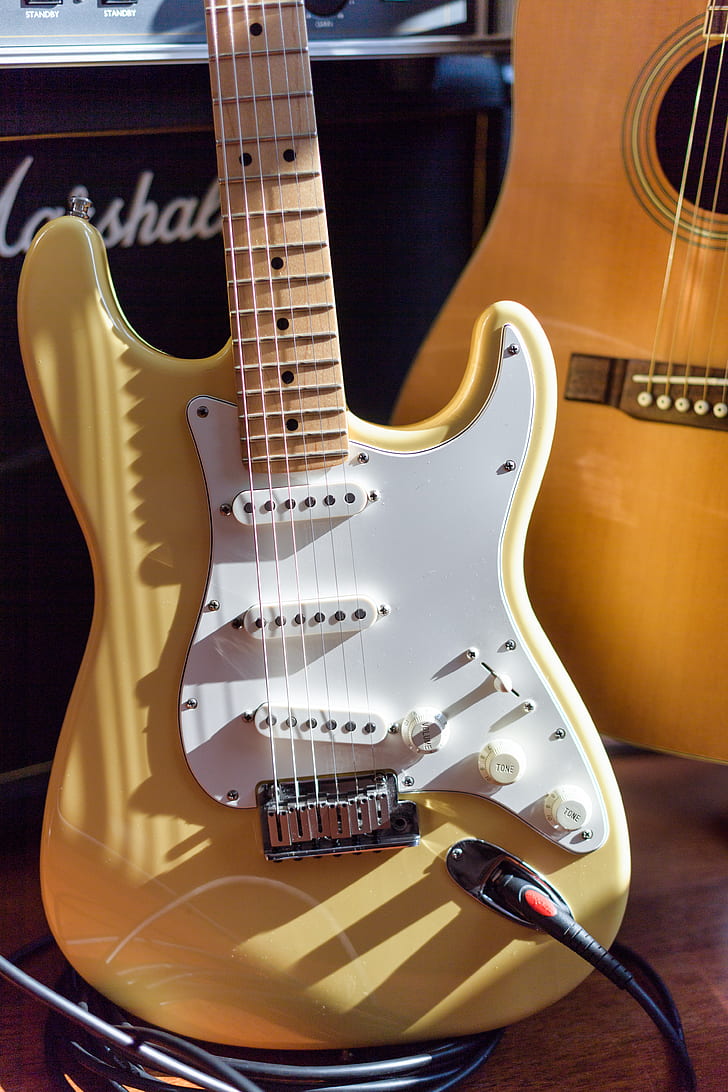 yellow and white electric guitar