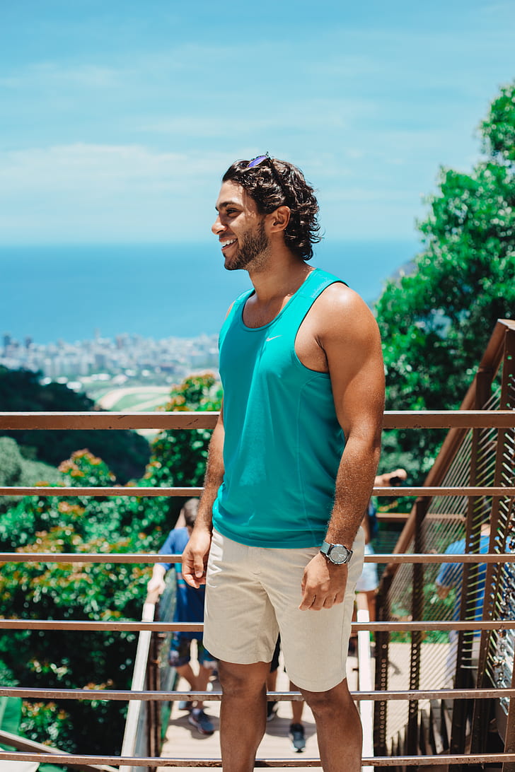 person in blue tank top standing near railings