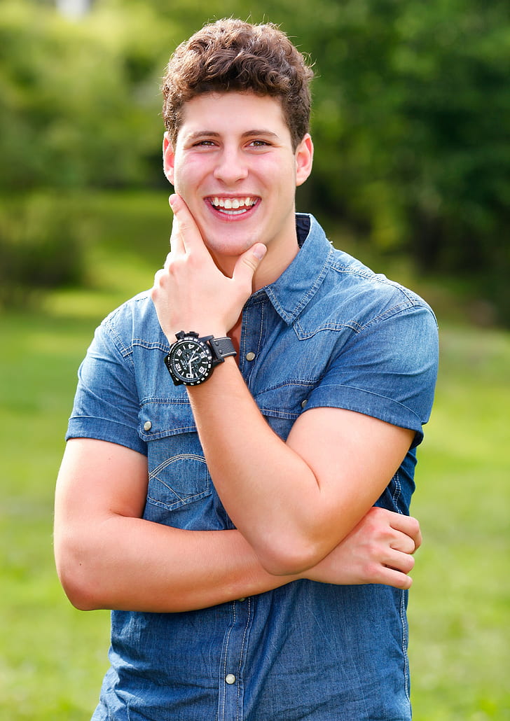 man smiling wearing denim button-up shirt