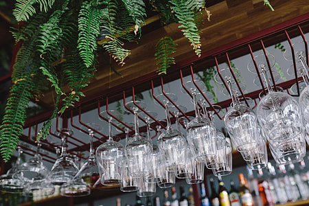 A big bunch of wine glasses hanging from a holder