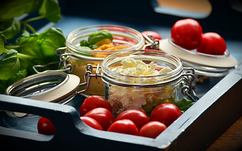selective focus photo of vegetables in clear glass jars