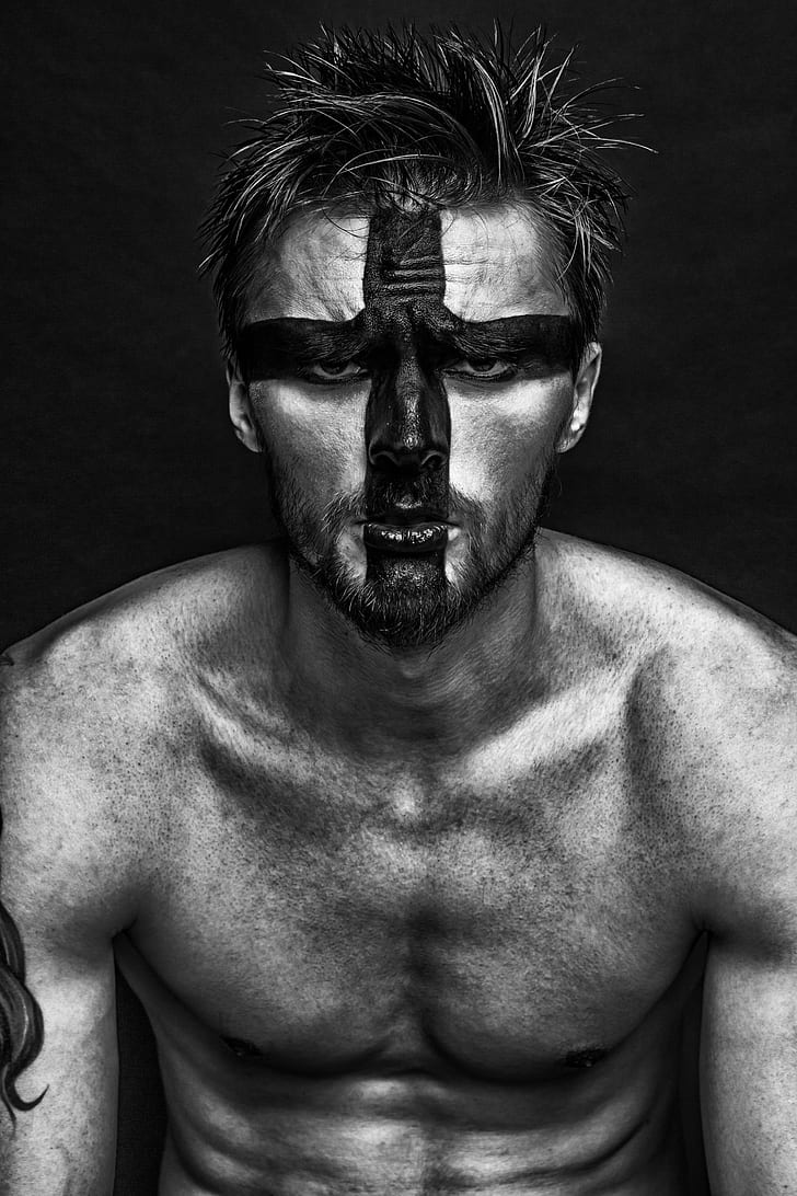 man with painted face grayscale photo