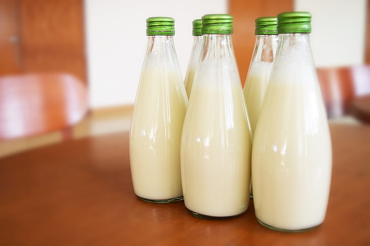 five bottles of milks on table