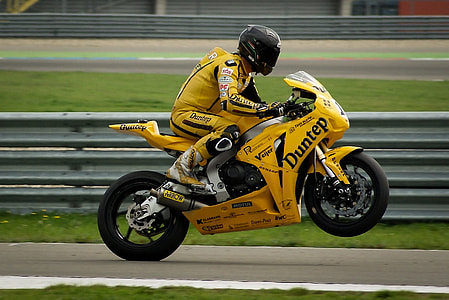 man wearing black full-face helmet riding yellow naked motorcycle