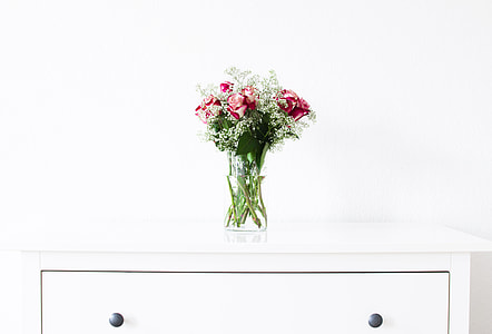 pink and white floral bundle in vase on white wooden dresser