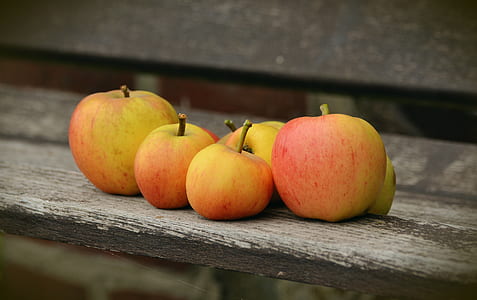 red-and-yellow apples on gray wooden surface