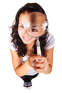 woman in scoop neck shirt holding magnifying glass