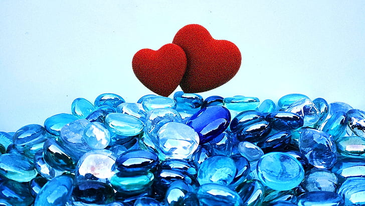 blue pebbles with two red hearts on top