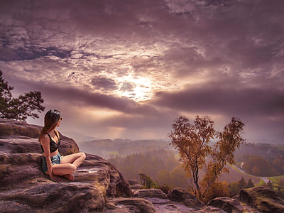 woman sitting on stone during golden hour