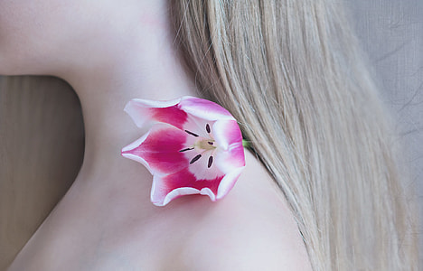 white and pink tulip flower on woman's shoulder