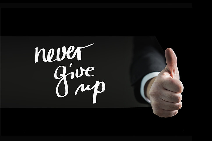 human hand with never give up text overlay