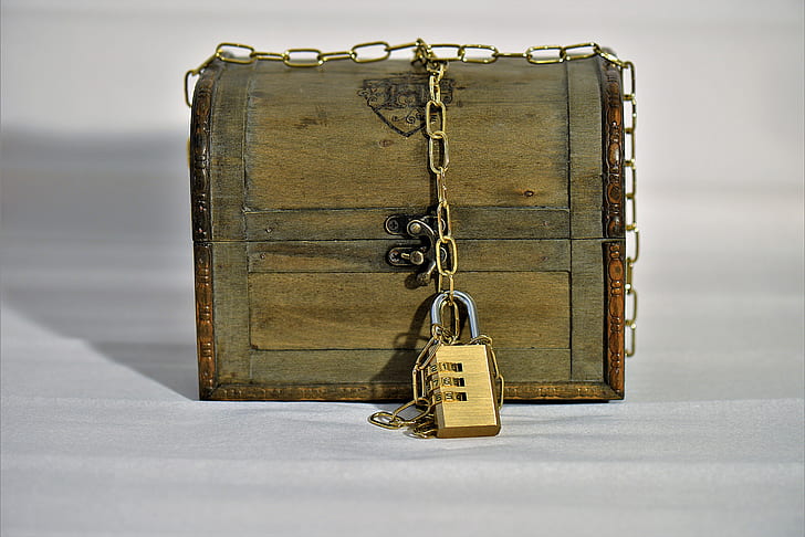 brown wooden trunk box with brass-colored padlock and chain