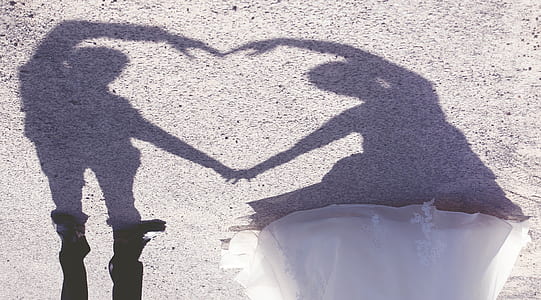 man and woman forming heart shadow