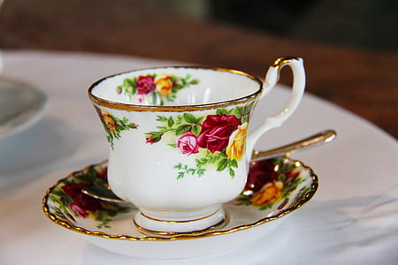 photo of white floral teacup and saucer with teaspoon