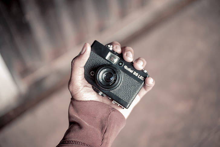 person holding vintage black camera