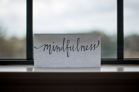 selective photo of Mindfulness printed paper on clear glass window