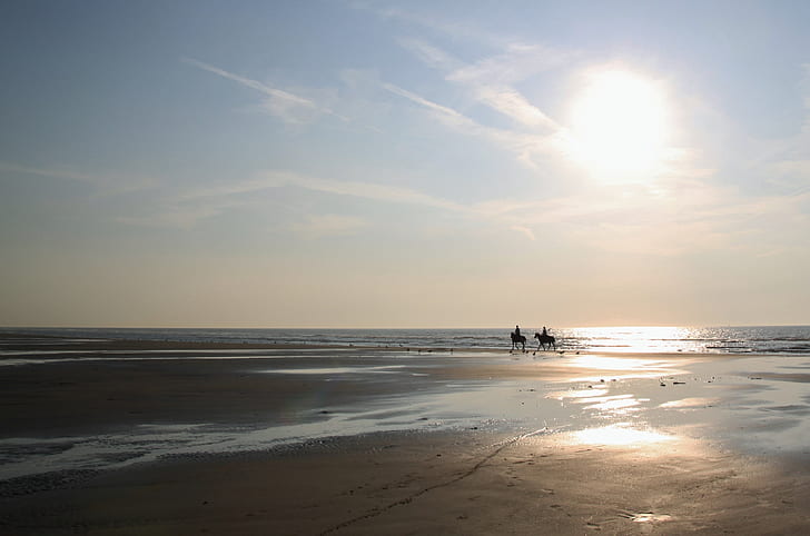 silhouette of two person riding on horse during sunrise
