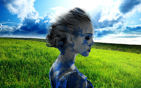 woman with blue paint of face near green field