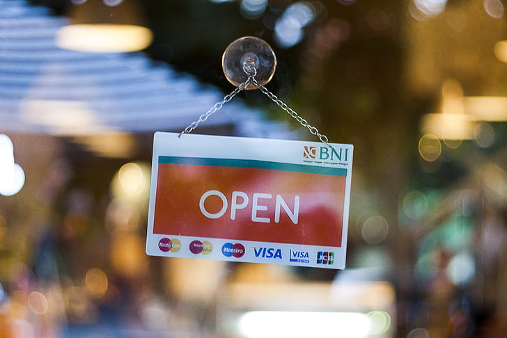 selective focus photographed of open hanging signboard