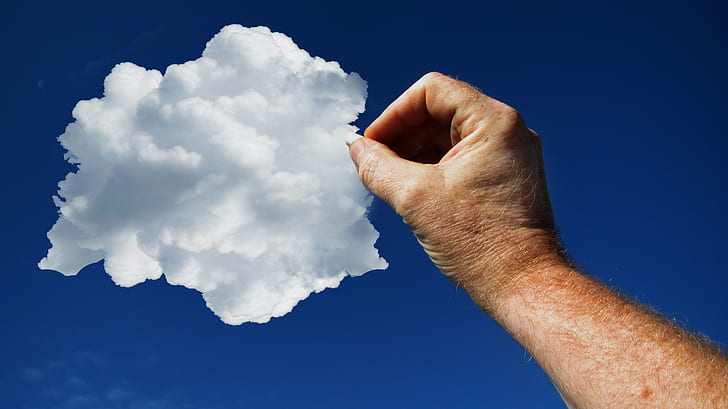 low angle photo of pointing right human arm towards white cloud on blue sky during daytime