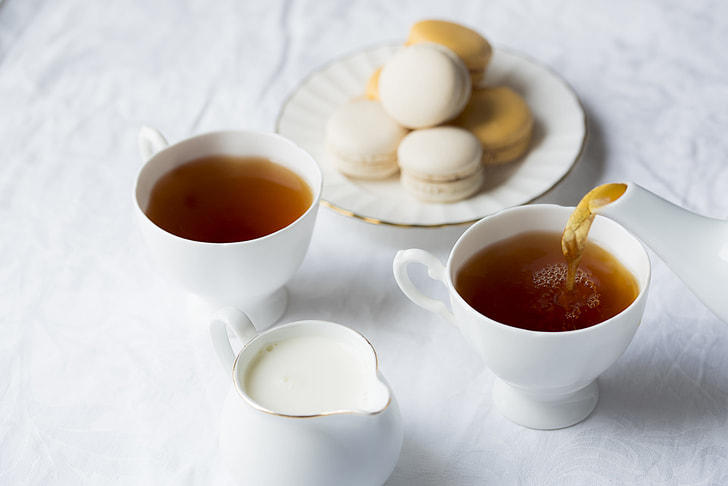 two white ceramic tea cups and white teapot