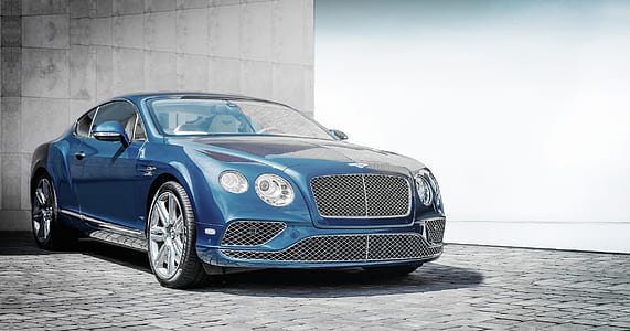 blue Bentley Continental coupe near concrete building