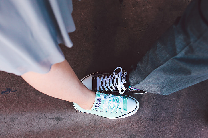 man and woman wearing black and teal low-top sneakers