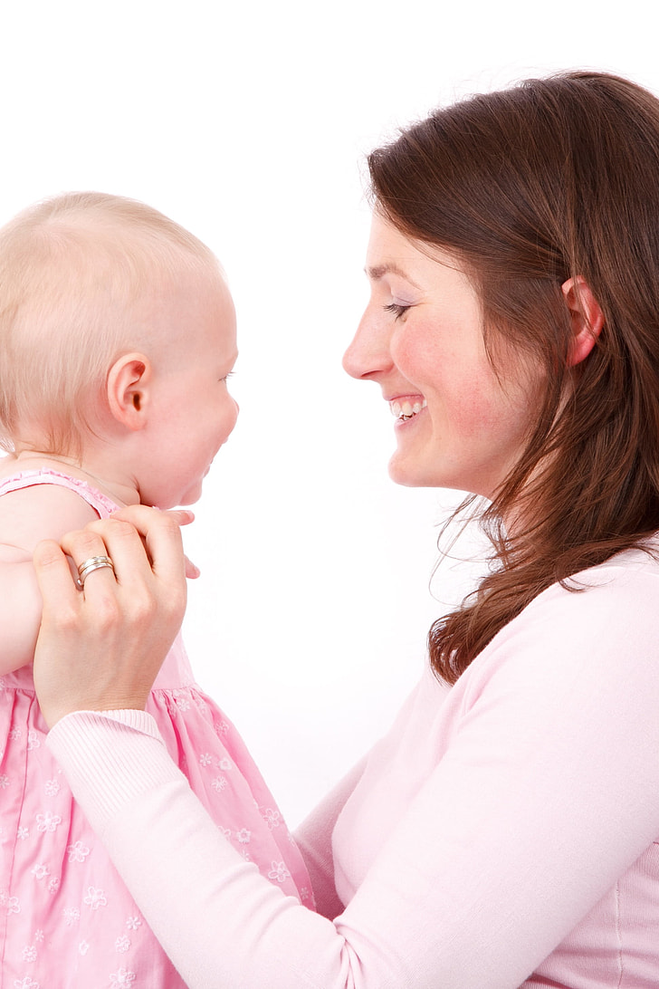 mother facing her baby wearing pink sleeveless dress