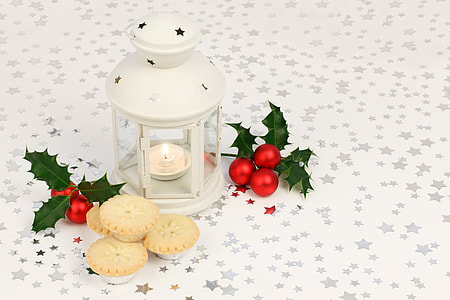 white candle lantern near the chrysanthemum and cookies