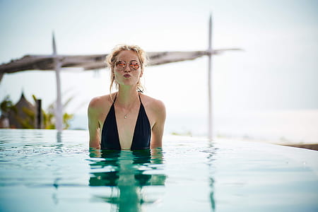 woman wearing black swimsuit in pool during daytime